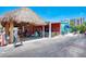 A colorful restaurant with outdoor seating under a thatched roof at 9122 Midnight Pass Rd # 24, Sarasota, FL 34242