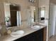 Bathroom with double sinks, framed mirrors and decorative tile backsplash at 4906 Peridia E Blvd, Bradenton, FL 34203