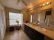 Bathroom featuring a double vanity and a window providing natural light at 4906 Peridia E Blvd, Bradenton, FL 34203