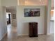 Hallway with tile flooring, art, and a vintage radio-cabinet near the kitchen entrance at 4906 Peridia E Blvd, Bradenton, FL 34203