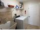 A laundry room featuring a washer, dryer, utility sink, and shelving at 4906 Peridia E Blvd, Bradenton, FL 34203