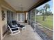 Cozy screened lanai with seating, tile flooring, and peaceful backyard views at 4906 Peridia E Blvd, Bradenton, FL 34203