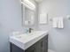 Bathroom features a modern vanity with a white countertop, a sink, and a decorative mirror at 7251 Sunnybrook Blvd, Englewood, FL 34224