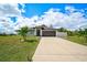 Beautiful home exterior with a manicured lawn and a long driveway at 7251 Sunnybrook Blvd, Englewood, FL 34224