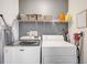 Laundry room with a washer, dryer, storage shelf, and gray accent wall at 7251 Sunnybrook Blvd, Englewood, FL 34224