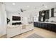Open-concept living room with a modern kitchen featuring dark cabinets, light countertops, and stainless-steel appliances at 7251 Sunnybrook Blvd, Englewood, FL 34224