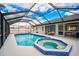 Backyard features a screened-in pool and hot tub, perfect for outdoor relaxation at 7251 Sunnybrook Blvd, Englewood, FL 34224