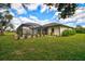 Screened-in pool and spa featuring lush landscaping, all with a view of the sparkling water and sunny sky at 7251 Sunnybrook Blvd, Englewood, FL 34224