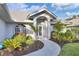 Inviting front entrance with lush landscaping, curved walkway, and charming architectural details at 1060 Truman St, Nokomis, FL 34275