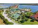 Community aerial view of tennis courts, clubhouse, pool, and lakefront homes at 108 Maraviya Blvd, Nokomis, FL 34275