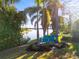 Secluded backyard featuring serene lake views and Adirondack chairs beneath swaying palm trees at 108 Maraviya Blvd, Nokomis, FL 34275