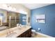 Bathroom featuring double sinks, and an enclosed glass walk-in shower and tub with modern fixtures at 108 Maraviya Blvd, Nokomis, FL 34275