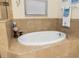 Relaxing bathroom featuring a modern bathtub with tan tile accents, providing a tranquil retreat at 108 Maraviya Blvd, Nokomis, FL 34275