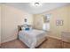 Inviting bedroom featuring a patterned bedspread, a bright window, and a neutral color scheme at 108 Maraviya Blvd, Nokomis, FL 34275
