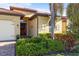 Charming single-story home featuring a barrel tile roof, wood front door, and lush landscaping at 108 Maraviya Blvd, Nokomis, FL 34275