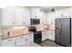 Modern kitchen features granite countertops, tiled backsplash, stainless appliances, and bright white cabinets at 108 Maraviya Blvd, Nokomis, FL 34275