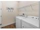Bright laundry room features a washer, a dryer, a hanging rack, and stylish décor at 108 Maraviya Blvd, Nokomis, FL 34275