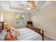 Comfortable bedroom featuring a ceiling fan, tropical throw pillows, and a large window with natural light at 108 Maraviya Blvd, Nokomis, FL 34275