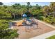Community playground featuring colorful play structures, slides, and climbing equipment amid lush landscaping at 108 Maraviya Blvd, Nokomis, FL 34275