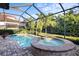 Inviting screened-in pool and spa with a brick-paved patio overlooking the manicured backyard at 108 Maraviya Blvd, Nokomis, FL 34275
