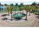 Community water fountain featuring a circular design surrounded by lush landscaping and palm trees at 108 Maraviya Blvd, Nokomis, FL 34275