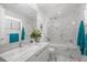 Elegant bathroom with marble walls, garden decor, a large mirror, and a soaking tub at 1155 N Gulfstream Ave # 708, Sarasota, FL 34236
