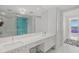 Bright bathroom with dual sinks, sleek cabinetry and walk-in shower with glass doors and seaside decorations at 1155 N Gulfstream Ave # 708, Sarasota, FL 34236
