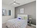 Cozy bedroom with a vibrant splatter-paint comforter, ceiling fan, and window view at 1155 N Gulfstream Ave # 708, Sarasota, FL 34236