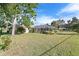 Expansive backyard featuring a screened-in pool area with ample green space and mature trees at 128 Da Vinci Dr, Nokomis, FL 34275