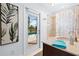 Bathroom with a view of the pool area, shower, stylish vanity, and a tropical-themed shower curtain at 128 Da Vinci Dr, Nokomis, FL 34275