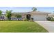 Charming single-story home with well-maintained lawn, lush landscaping, and attached two-car garage at 128 Da Vinci Dr, Nokomis, FL 34275