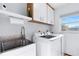 Functional laundry room featuring modern washer and dryer, plus cabinet storage at 128 Da Vinci Dr, Nokomis, FL 34275