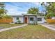 Charming single story home featuring a wooden door, black window trim and fresh landscaping at 1301 6Th W St, Palmetto, FL 34221