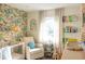 Bright Bedroom featuring a cozy armchair, crib, and playful wallpaper, creating a cheerful space at 1305 20Th W St, Bradenton, FL 34205