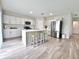 Bright kitchen with stainless steel appliances, a large center island with seating, and white cabinetry at 13068 Oak Hill Way, Parrish, FL 34219