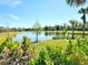 Picturesque lake view with manicured lawn and beautiful blue skies at 13068 Oak Hill Way, Parrish, FL 34219