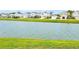 Picturesque view of the pond and landscaping with a view of neighborhood houses at 13068 Oak Hill Way, Parrish, FL 34219