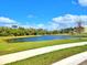 Serene pond view with grassy banks and community sidewalk at 13068 Oak Hill Way, Parrish, FL 34219