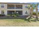 Rear exterior view of a two-story home with screened balconies and a lush green lawn at 13711 Messina Loop # 101, Bradenton, FL 34211