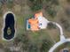 Aerial shot of a home with an orange tile roof, circular driveway, and a kidney shaped pond at 1450 & 12001 Bern Creek Loop, Sarasota, FL 34240