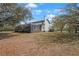 Spacious backyard view of the property featuring mature trees and a screened-in outdoor space at 1450 & 12001 Bern Creek Loop, Sarasota, FL 34240