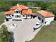 Aerial view of a stunning home, fountain, boat, and a sprawling driveway and landscape at 1450 & 12001 Bern Creek Loop, Sarasota, FL 34240