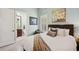 Calm bedroom showcases a floral art piece, plantation shutters, and an ensuite bath entrance at 14817 Secret Harbor Pl, Lakewood Ranch, FL 34202
