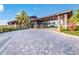 Welcoming porte-cochere entrance to the clubhouse with stone pillars and lush landscaping at 14817 Secret Harbor Pl, Lakewood Ranch, FL 34202