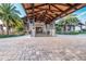Inviting porte-cochere entrance to the clubhouse, featuring dark beams, stone accents and landscaping at 14817 Secret Harbor Pl, Lakewood Ranch, FL 34202