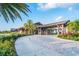 Stunning clubhouse entrance with porte-cochere, stone pillars, and lush landscaping at 14817 Secret Harbor Pl, Lakewood Ranch, FL 34202