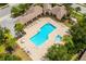An aerial of community pool with a spa, lounge chairs and palm trees for a resort atmosphere at 14817 Secret Harbor Pl, Lakewood Ranch, FL 34202