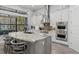 Modern kitchen featuring stainless steel appliances, a large island, and statement lighting at 14817 Secret Harbor Pl, Lakewood Ranch, FL 34202