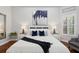 Well-lit bedroom features plush bedding, stylish nightstands, and contemporary artwork above the bed at 14817 Secret Harbor Pl, Lakewood Ranch, FL 34202