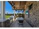 Covered outdoor kitchen with stainless steel appliances, a grill, and a dining area at 14817 Secret Harbor Pl, Lakewood Ranch, FL 34202